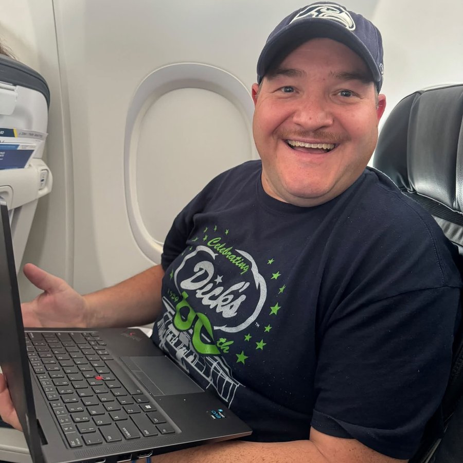 Nick Reef, founder of OpsHQ Digital, working on his laptop during a flight